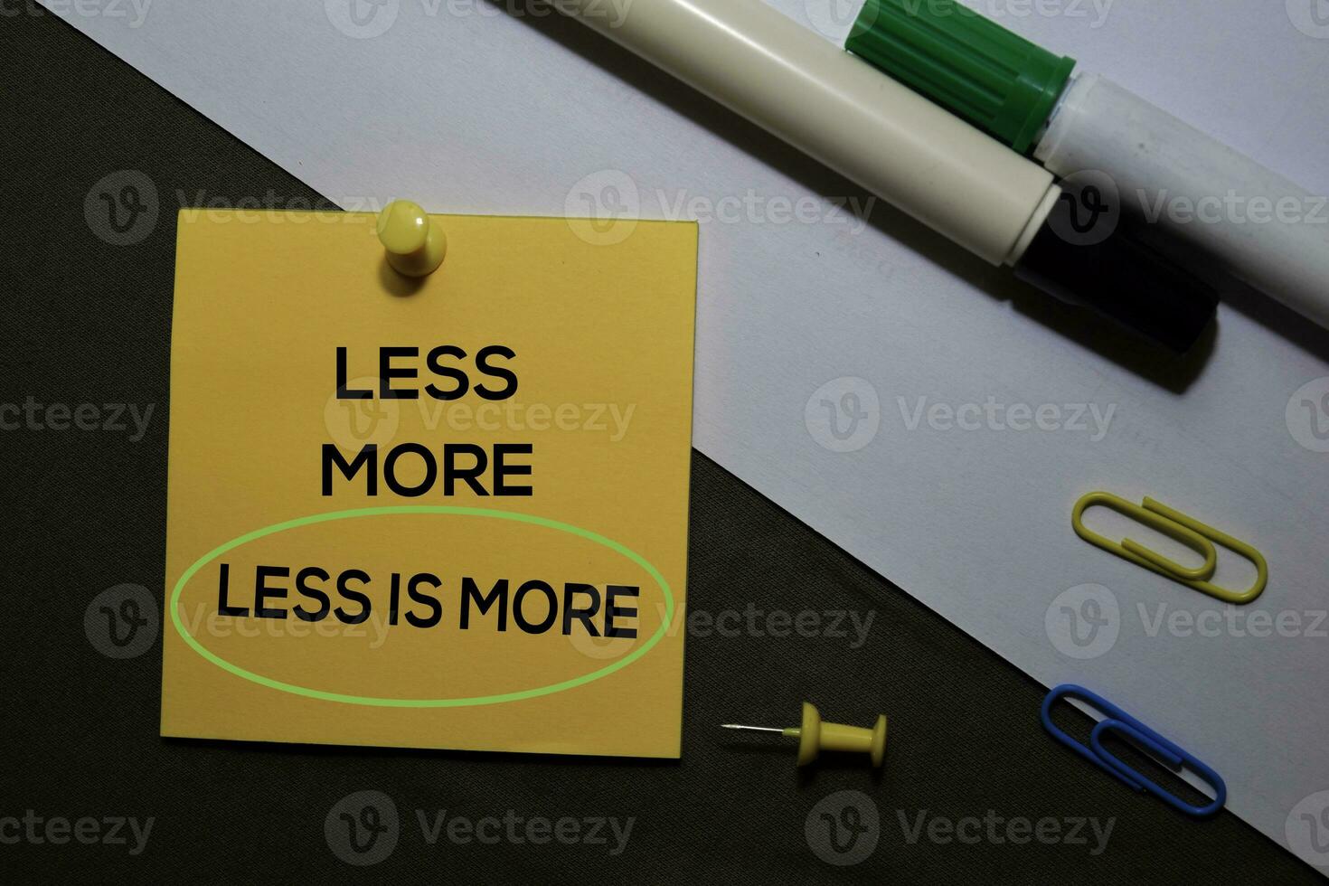 Less is More on sticky notes isolated on black white background photo