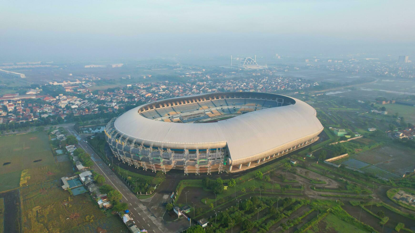 Aerial view of the Beautiful scenery Gelora Bandung Lautan Api Football or Soccer Stadium in the Morning with Blue Sky. Bandung, Indonesia, May 6, 2022 photo
