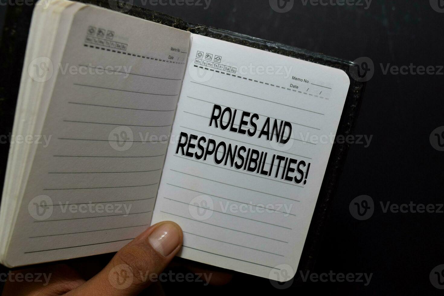 Roles and Responsibilites write on notebook isolated on black background photo