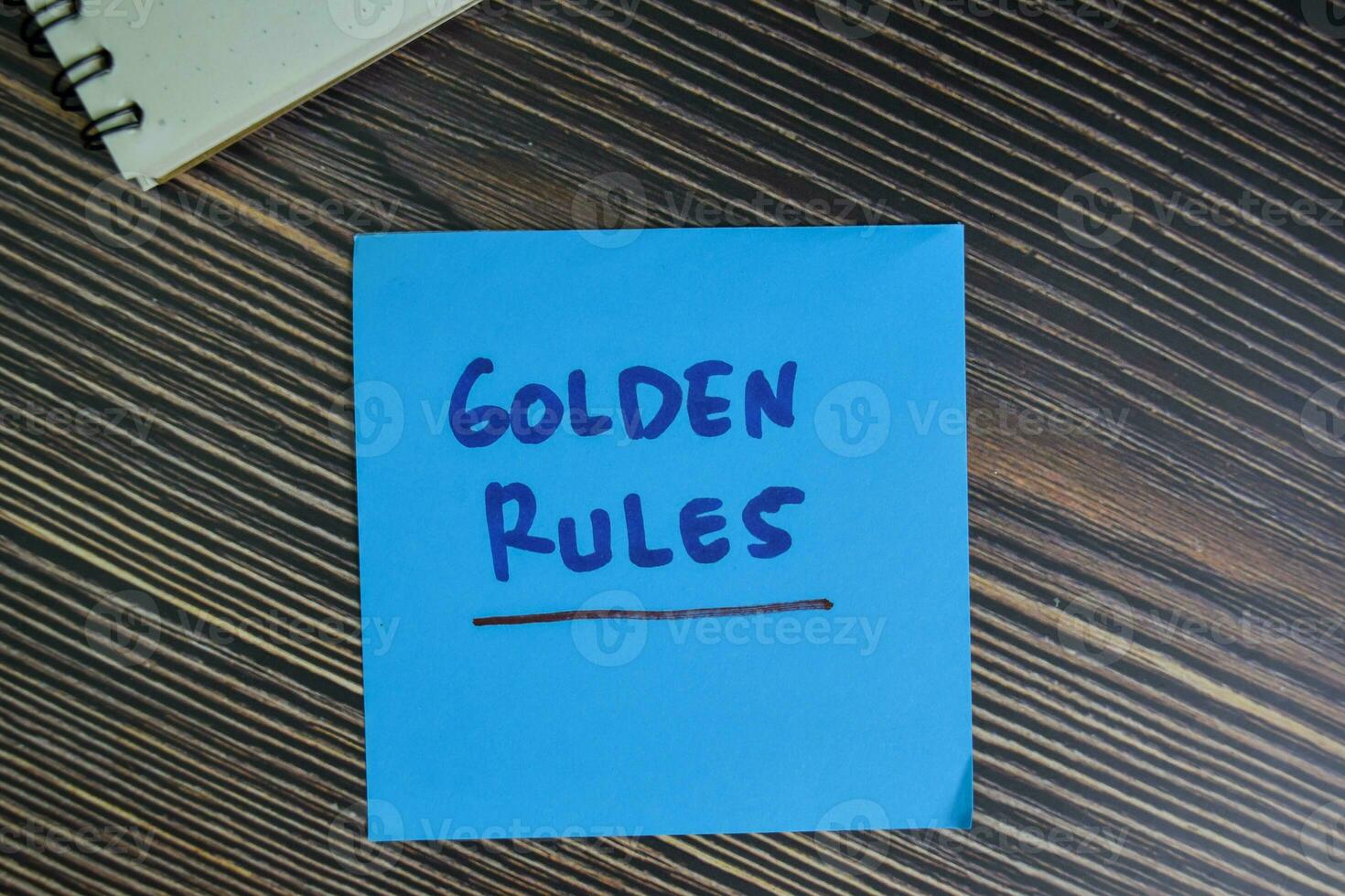 Golden Rules write on sticky notes isolated on Wooden Table. photo