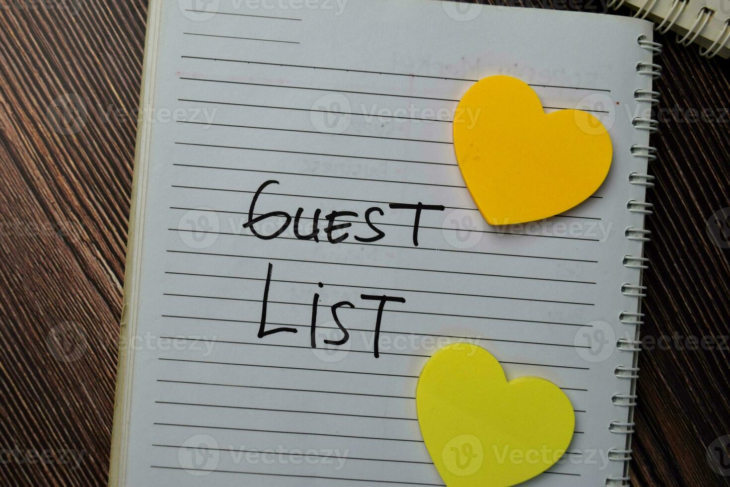 Guest List write on a book with keywords isolated wooden table. photo