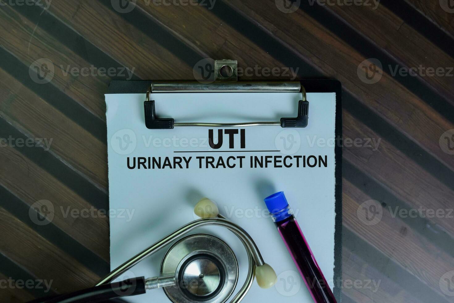 UTI - Urinary Tract Infection write on a paperwork isolated on Wooden Table. photo