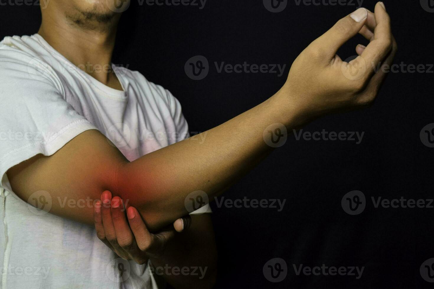 asiático hombre participación su mano. él siente dolor en su codo con negro antecedentes. médico o cuidado de la salud concepto foto