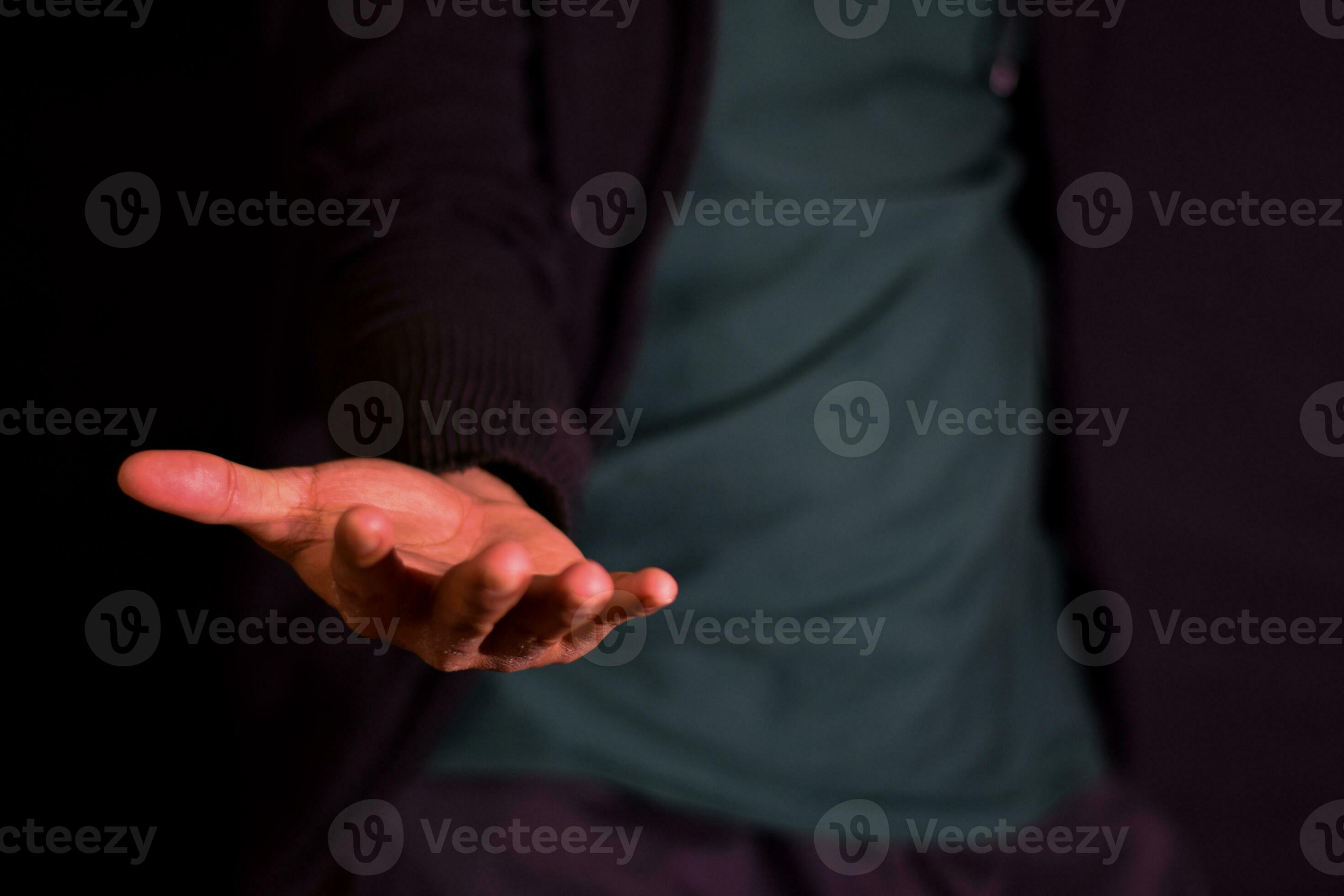 Young man showing hands it means of helping hand on dark black