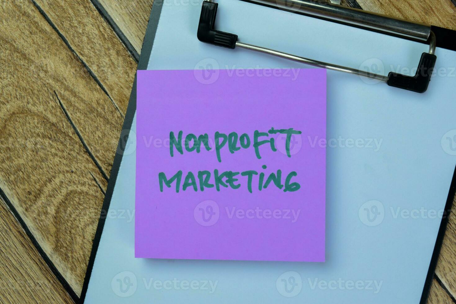 Concept of Nonprofit Marketing write on sticky notes isolated on Wooden Table. photo