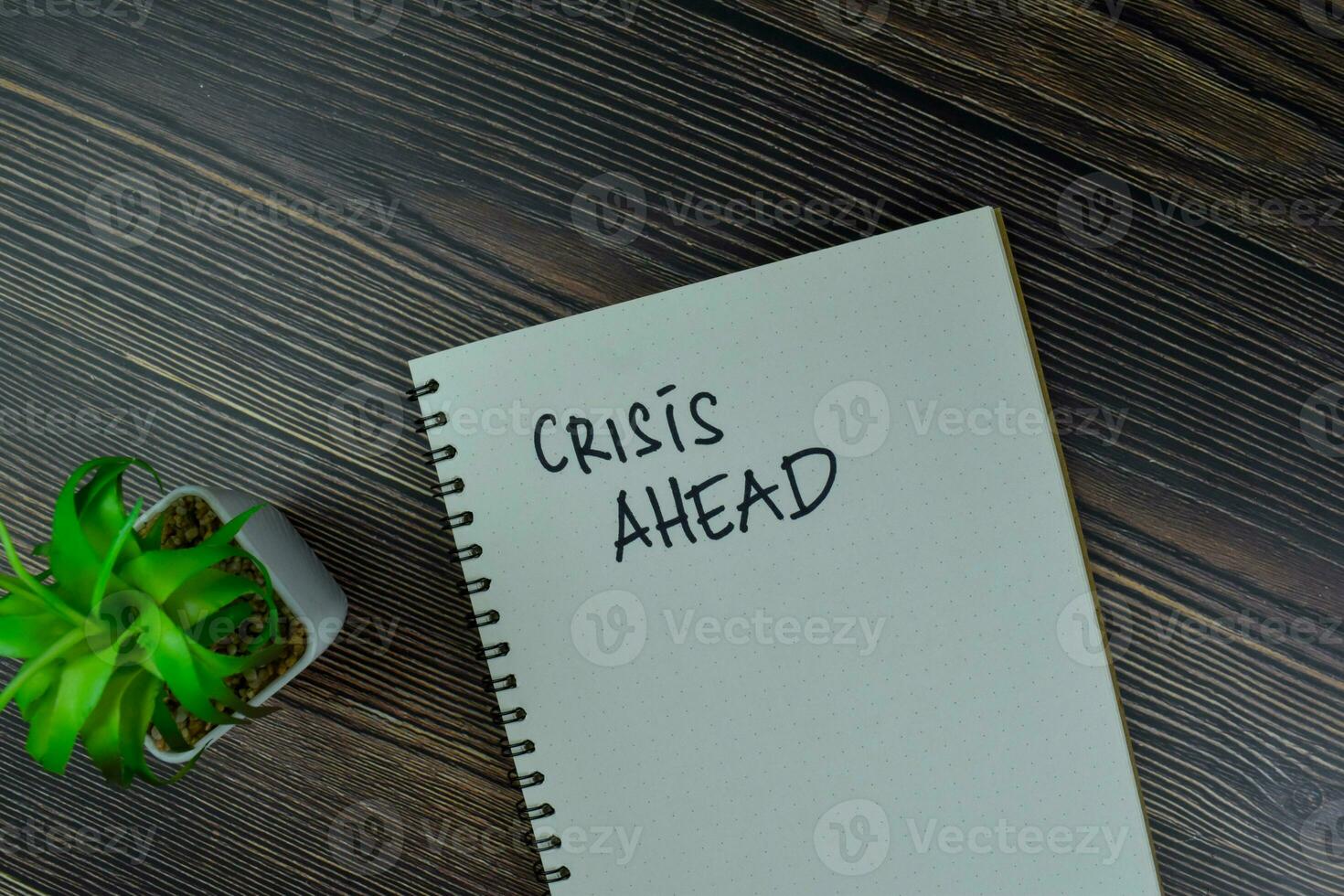 Crisis Ahead write on a book isolated on Wooden Table. photo