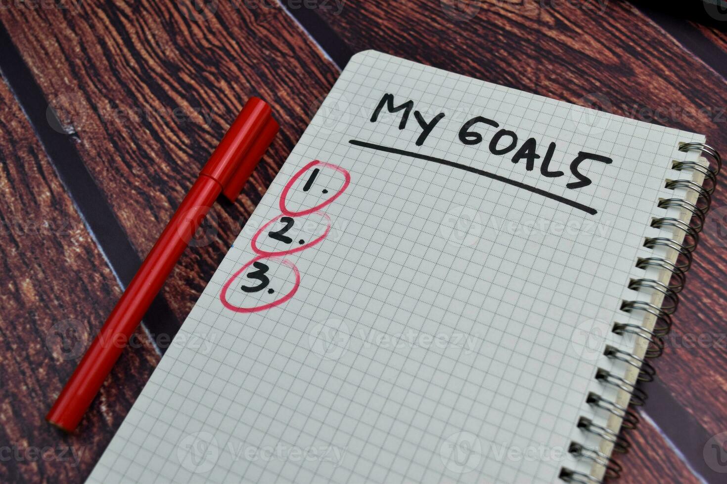 My Goals write on a book and number check Isolated on wooden table background photo