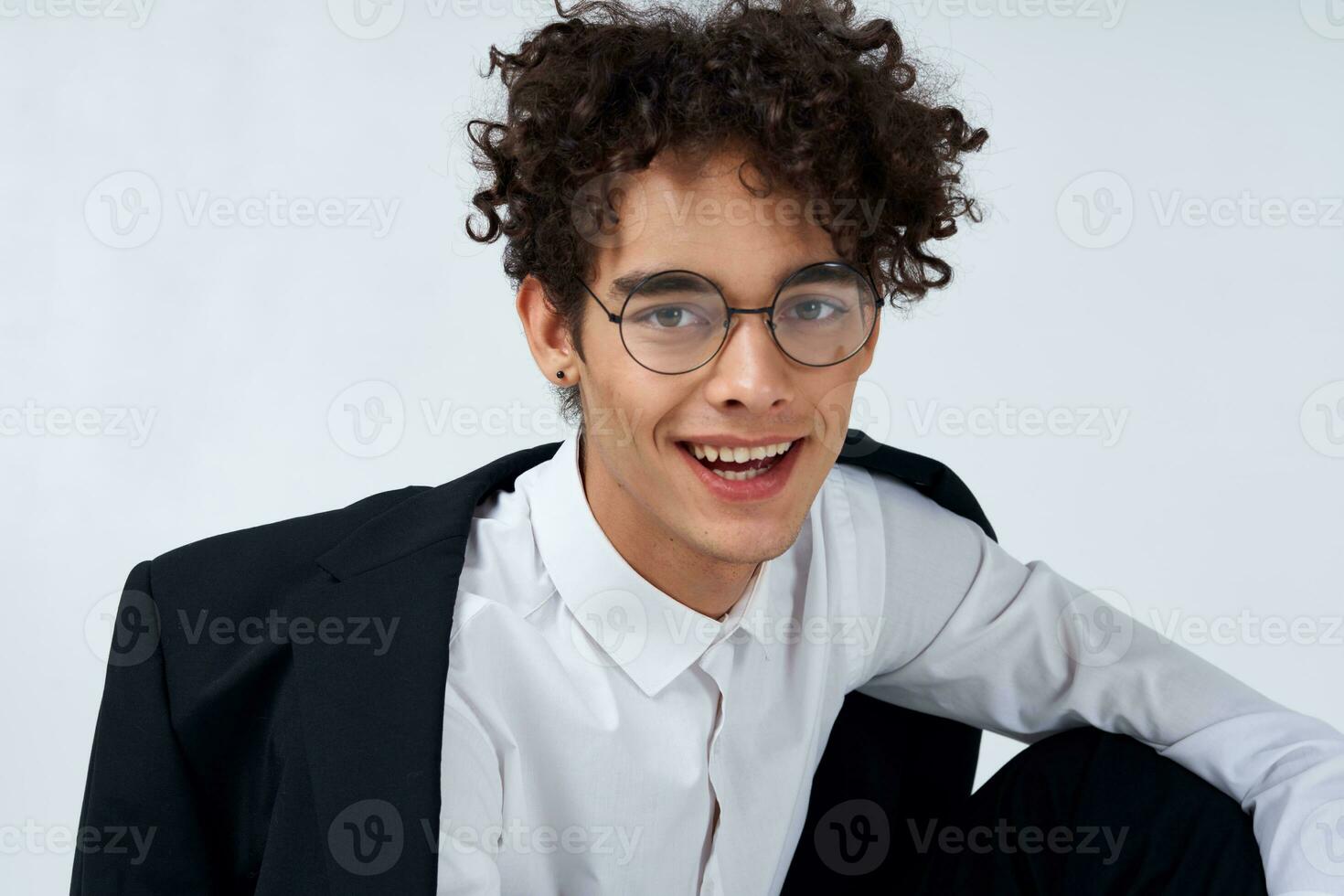 portrait of a curly-haired guy in a shirt in a jacket and glasses photo