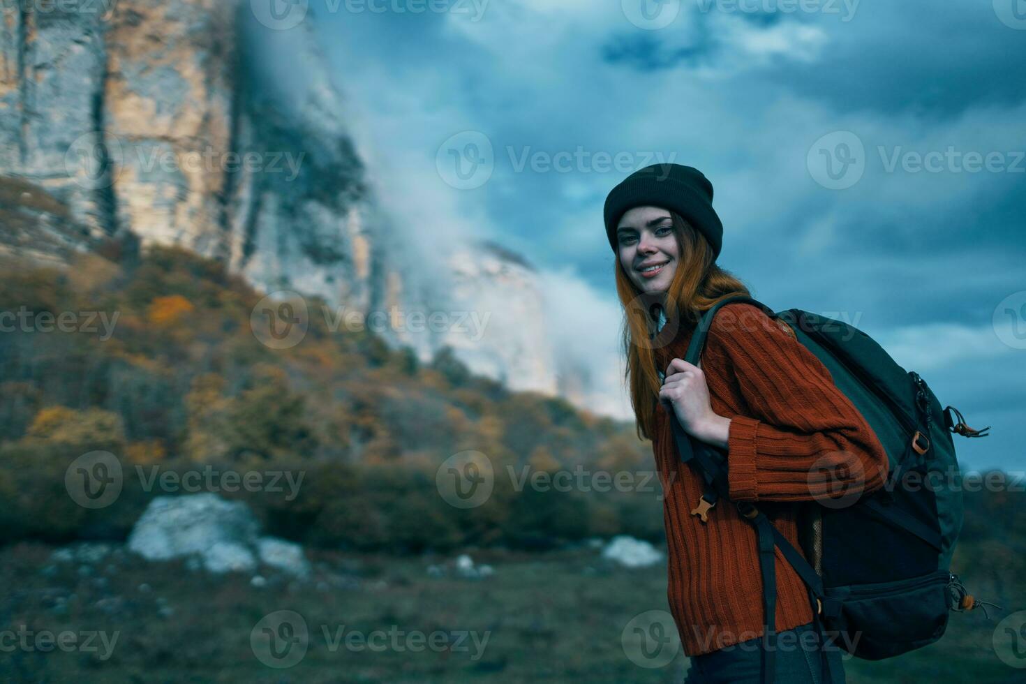 Traveler in a sweater with a backpack on her back tourism clouds sky landscape photo