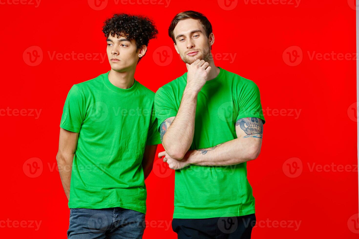 Two cheerful friends in green t-shirts are standing next to each other emotions isolated background photo