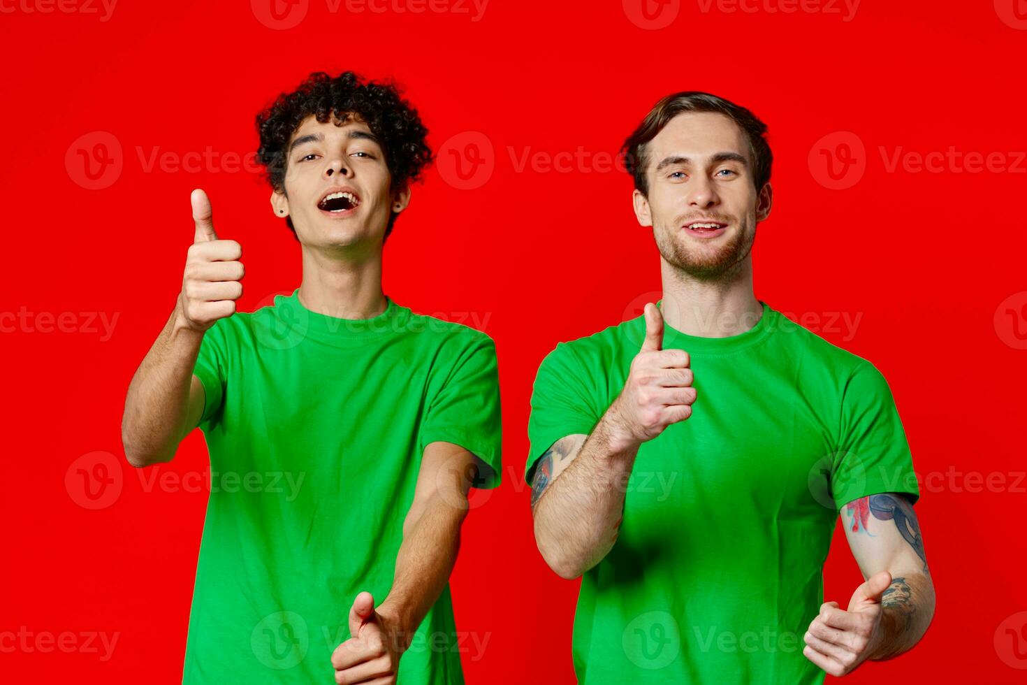 Two cheerful friends from green T-shirts gesticulate with hands emotions photo