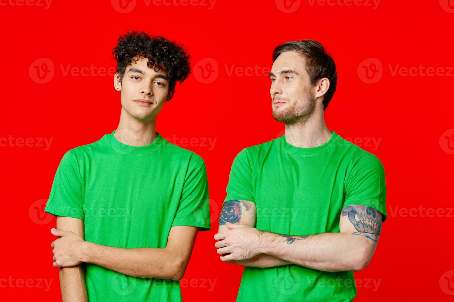 two men in green t-shirts are standing side by side communication photo