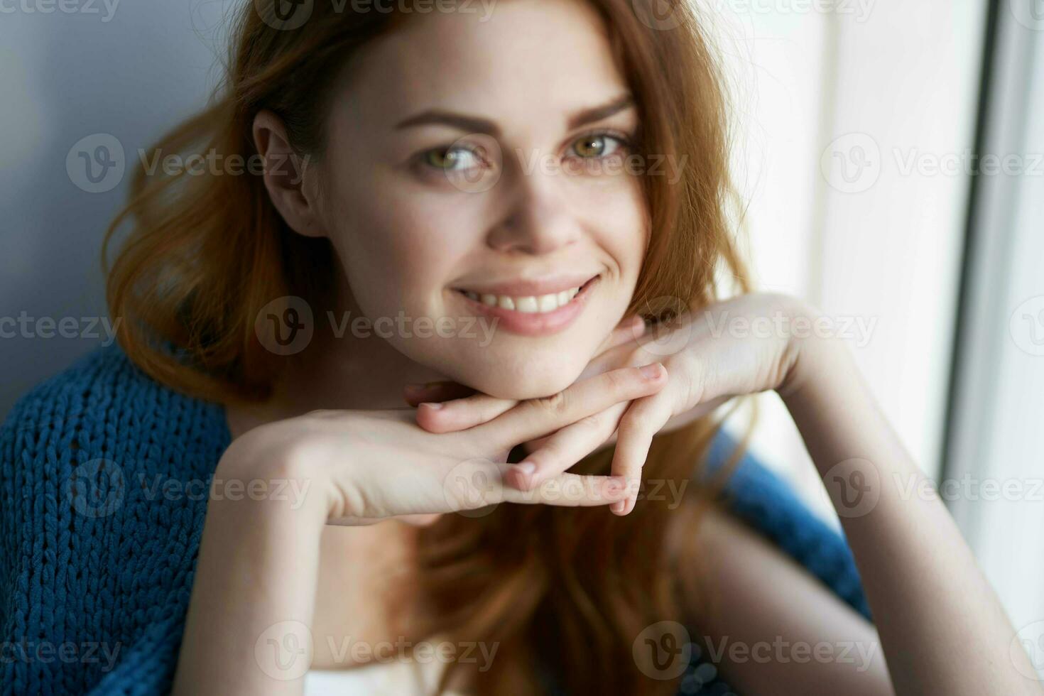 beautiful woman sitting on the windowsill with a blue plaid smile photo