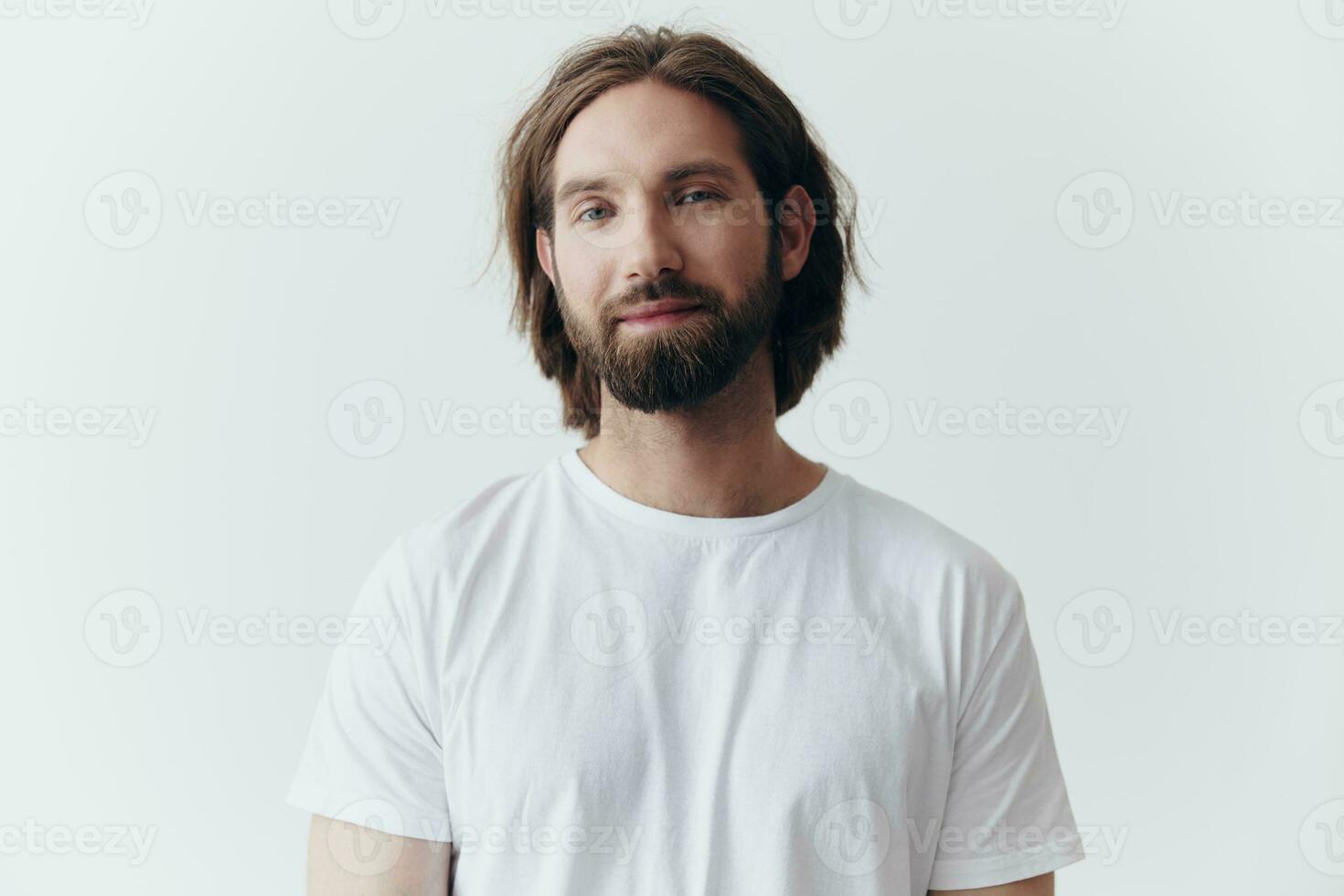 Portrait of a cheerful man with a black thick beard and long hair with a kind smile in a white T-shirt on a white isolated background photo