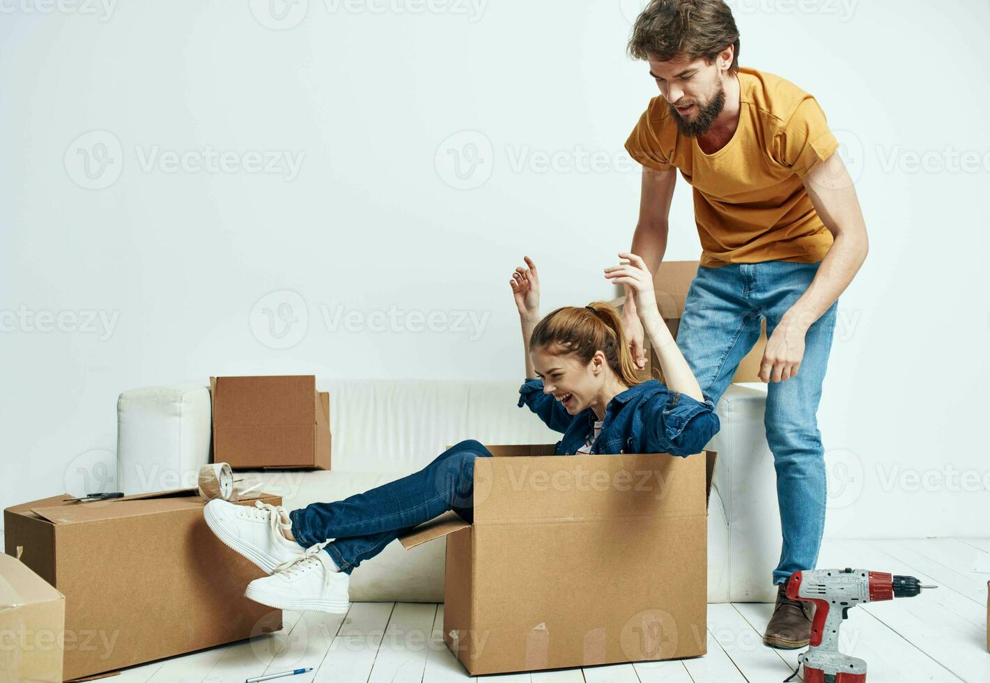 Cheerful man and woman on sofa at home interior moving boxes photo