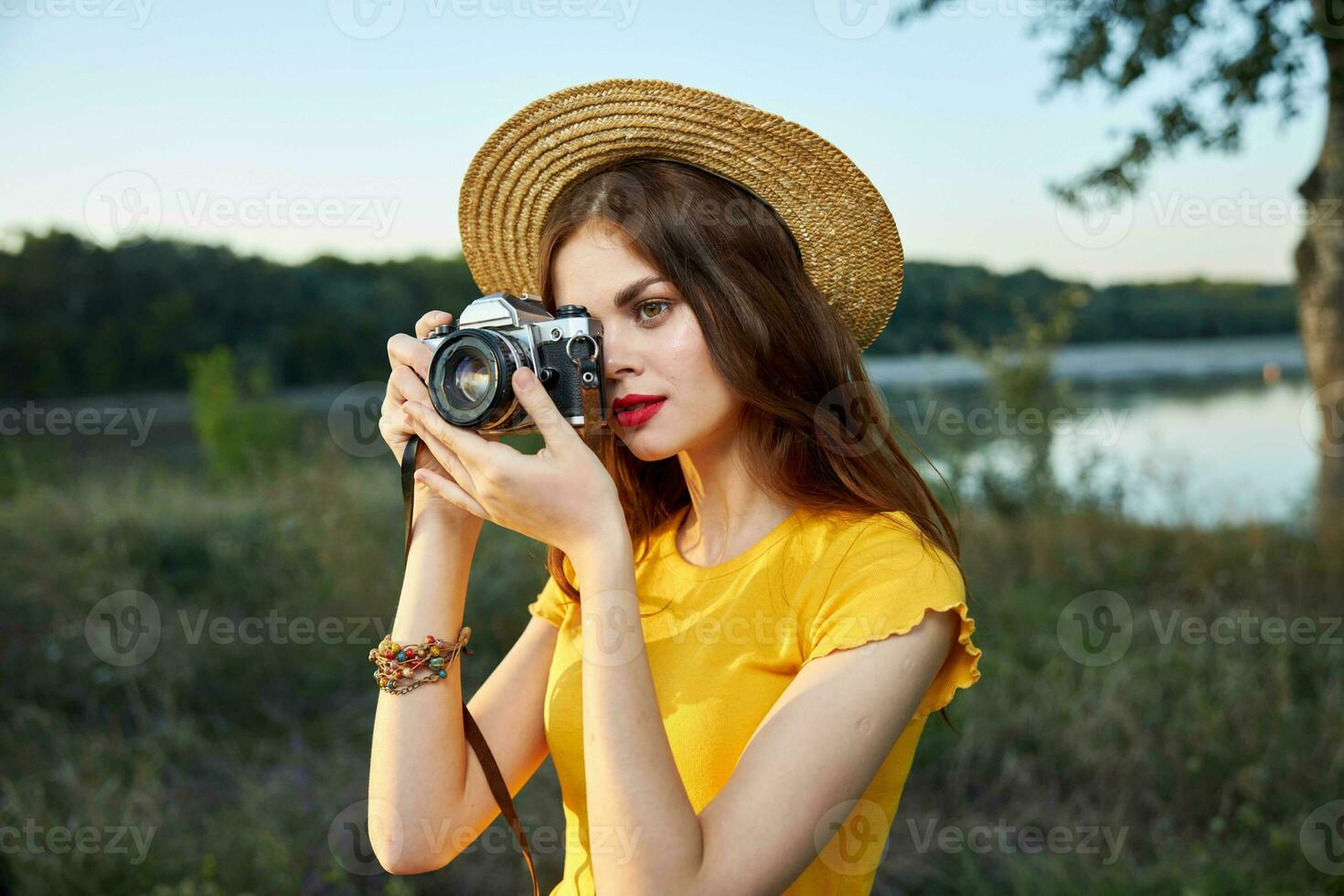 mujer con un cámara mira dentro el cámara lente naturaleza Fresco aire viaje foto