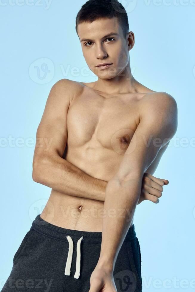 topless guy athletic physique workout blue background photo