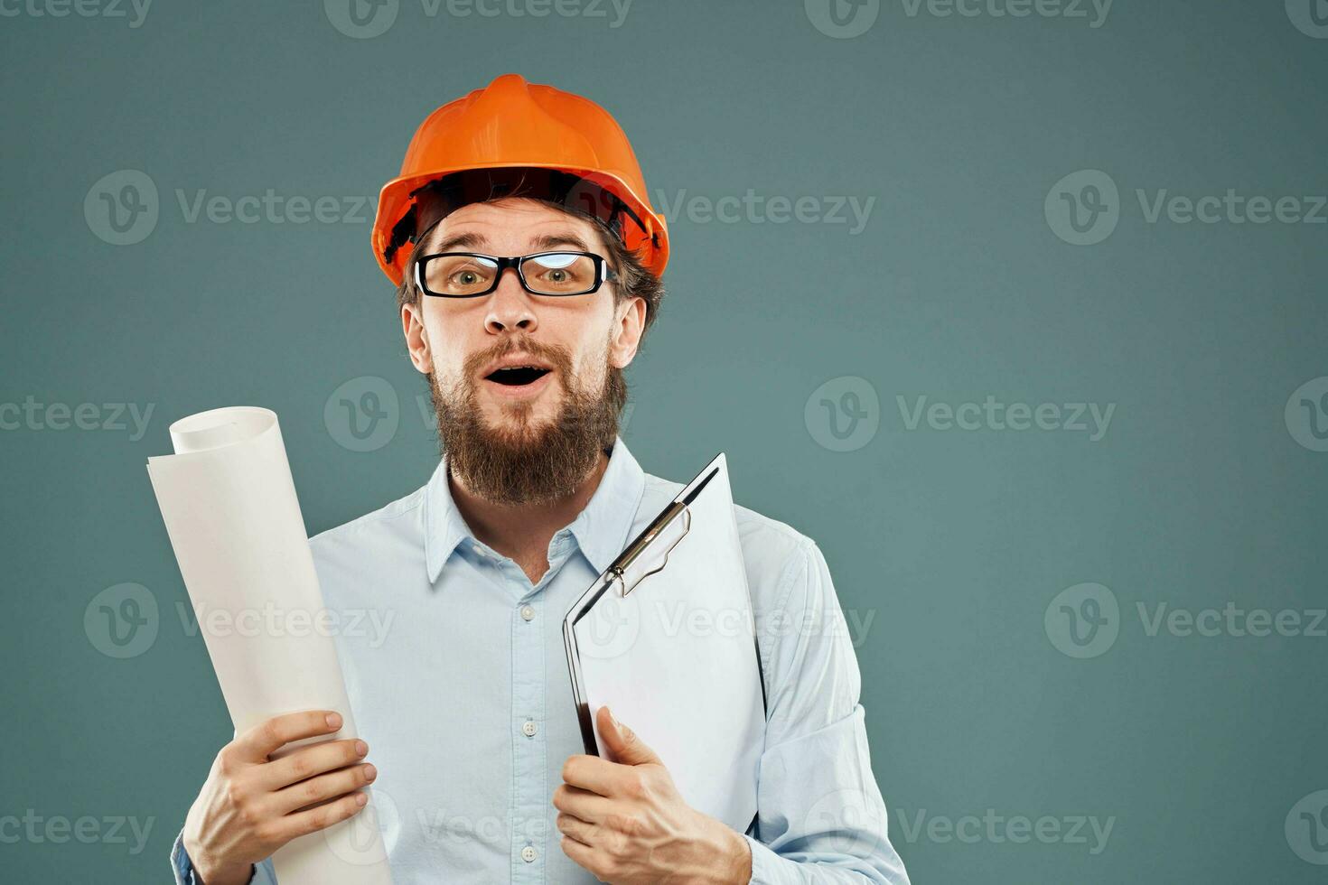 Cropped view of cheerful bearded man in orange paint in glasses with documents in hands photo