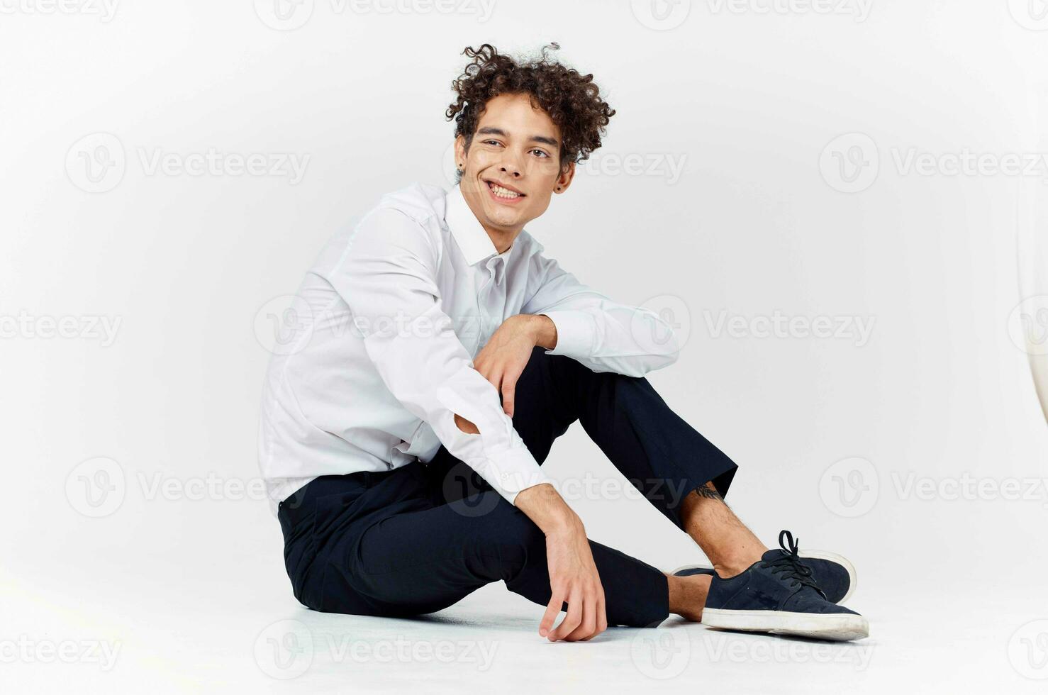 guy in a white shirt sitting on the floor curly hair fashion photo