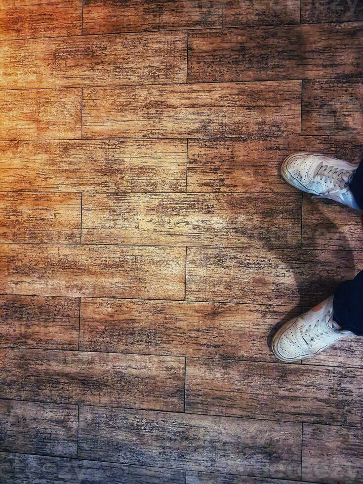 A pair of white shoes on a floor with a wooden texture. photo