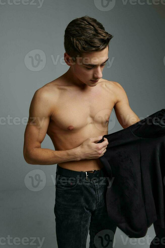 male topless black shirt in hands studio cropped view photo