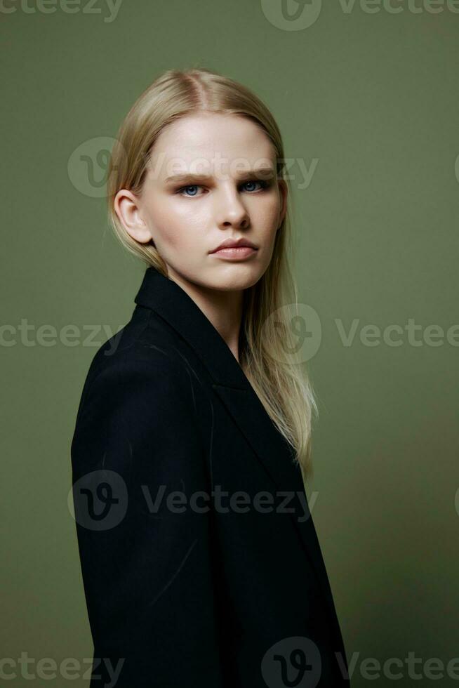 Cool banner for brands. An attractive cool professional model poses in a half-turn and looks at the camera on a green olive background in the studio photo