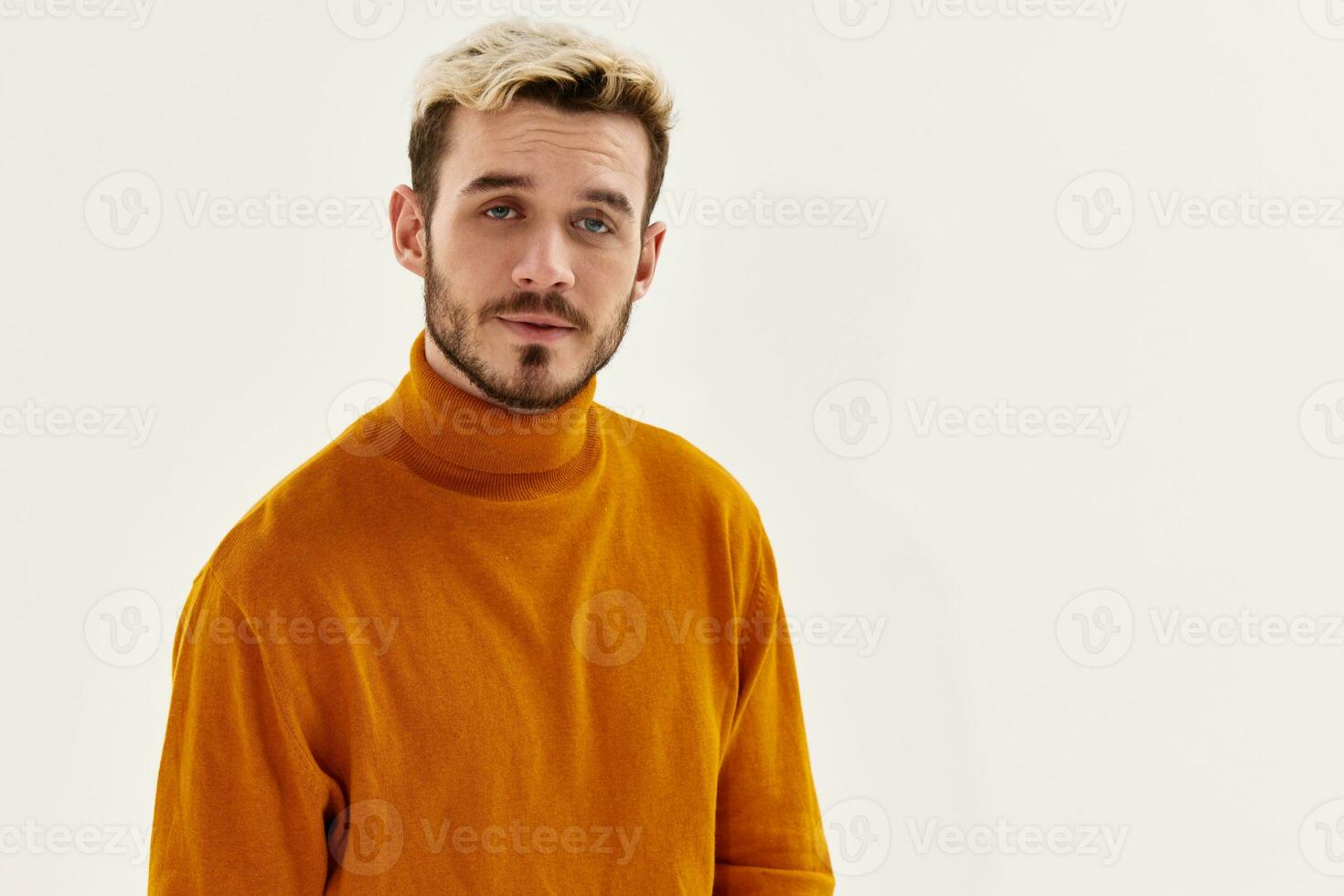 portrait of a nice guy with a beard blond orange sweater light background photo