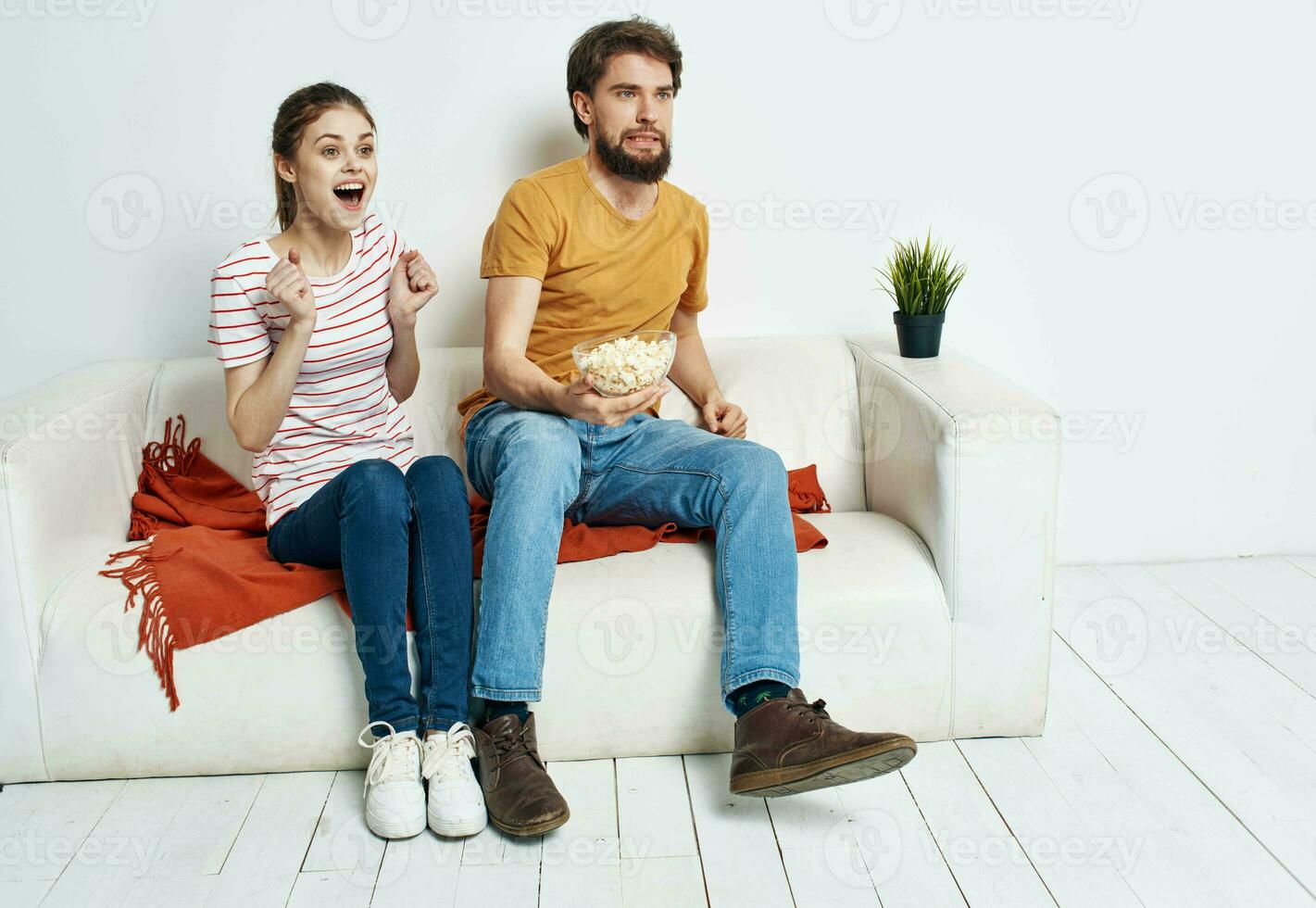 Men women with popcorn in a plate indoors on the sofa photo