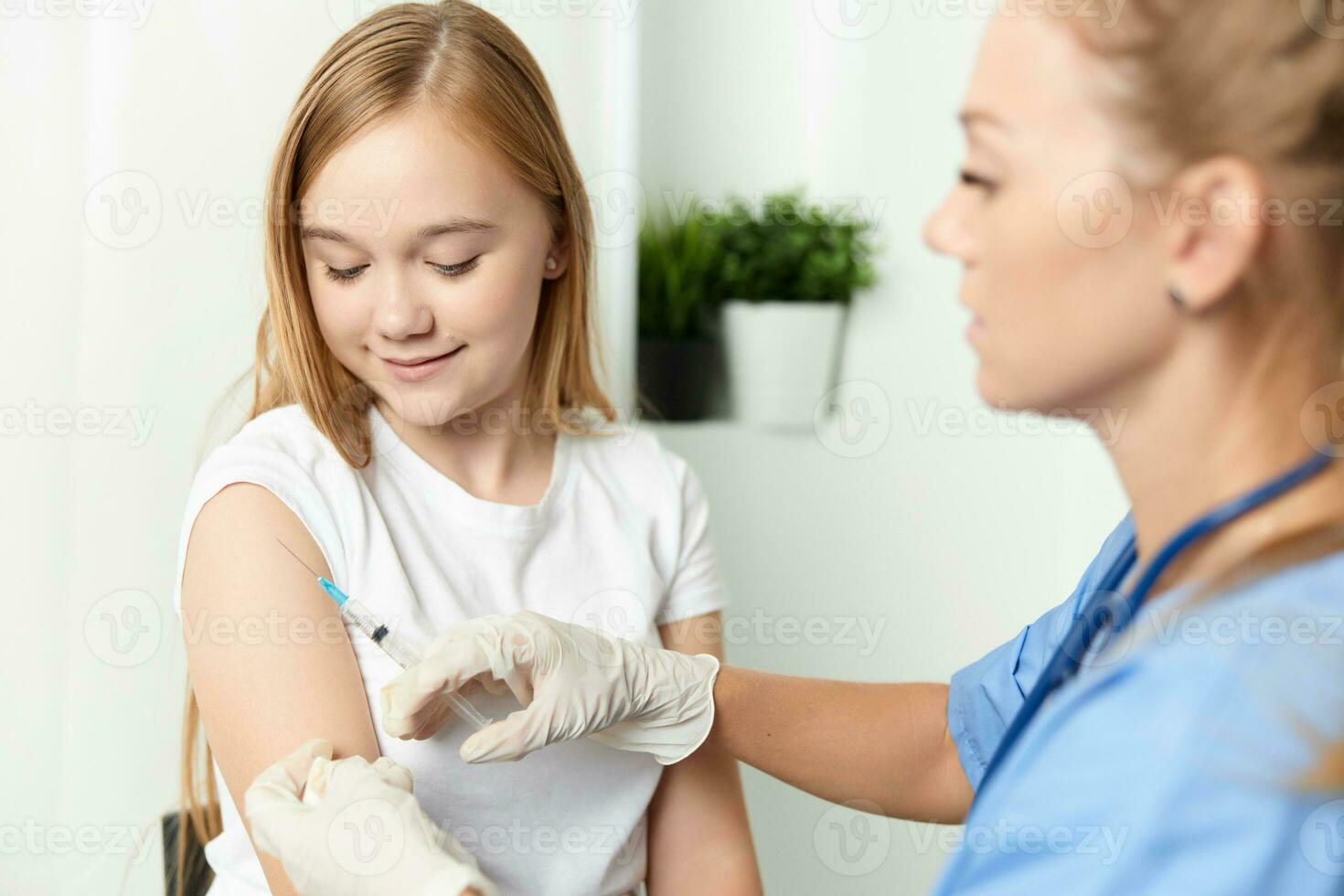 woman doctor giving a girl an injection in the arm vaccination photo