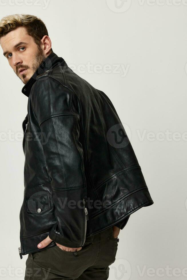 fashionable man in leather jacket turned his head back view photo