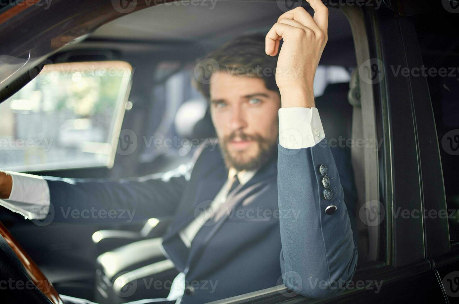 bearded man in a suit in a car a trip to work communication by phone photo