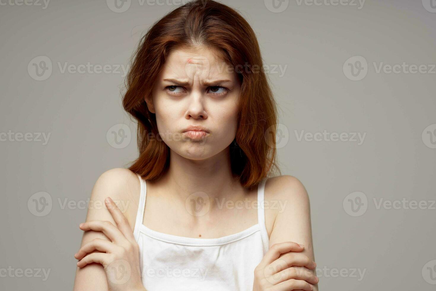 bonito mujer en un blanco camiseta espinillas en el cara aislado antecedentes foto