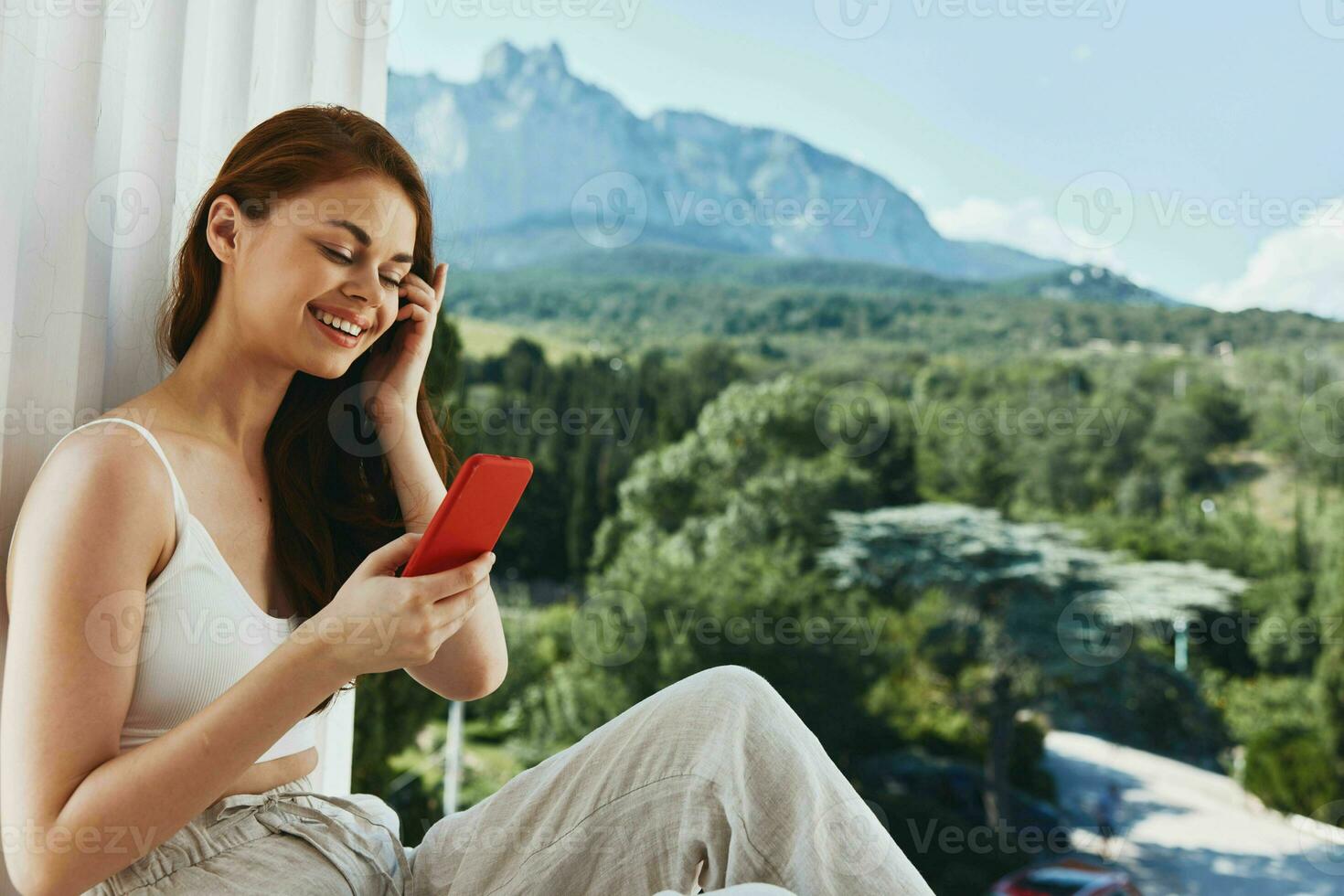 atractivo joven mujer con un rojo teléfono terraza al aire libre lujo paisaje ocio inalterado foto