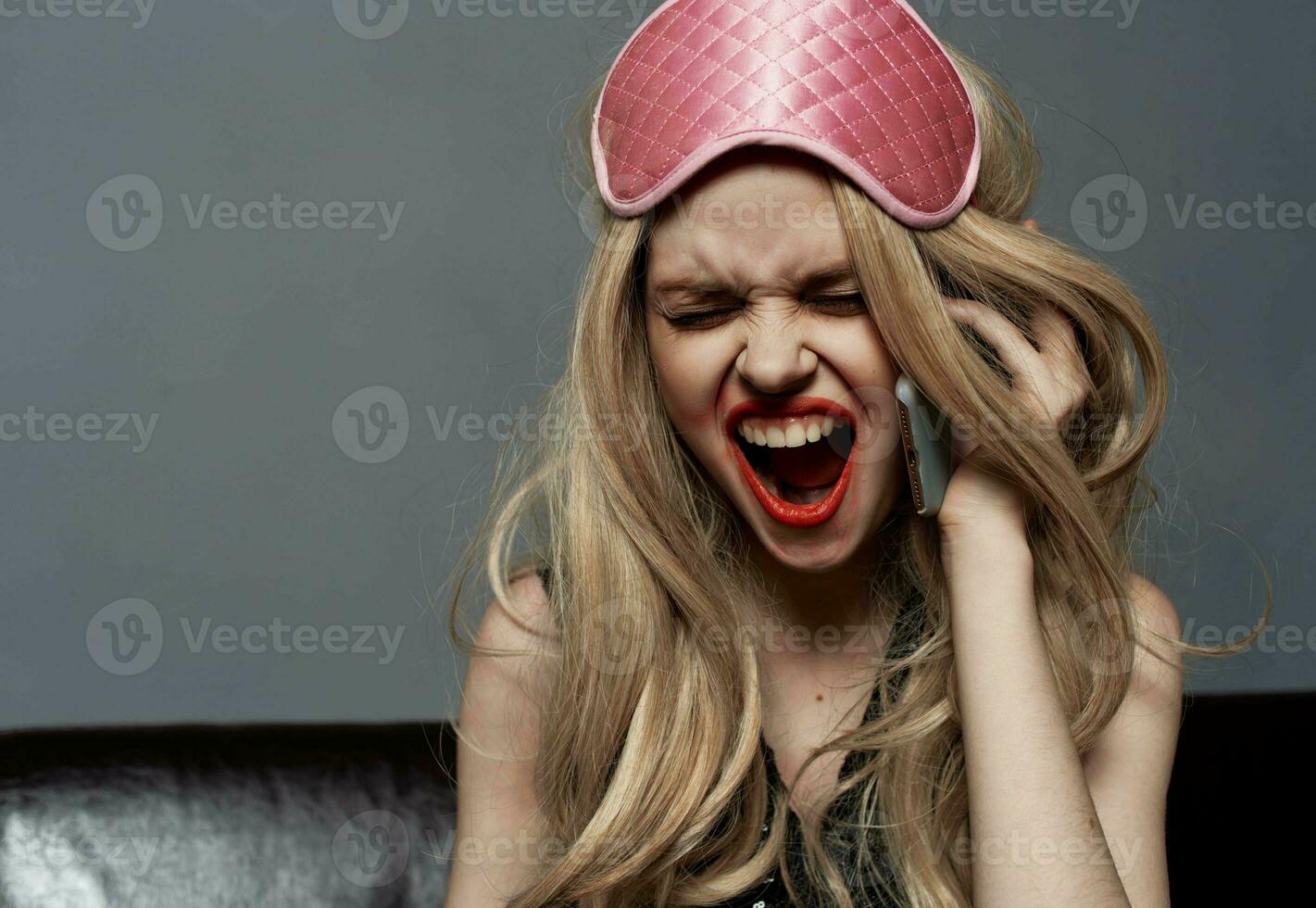 Portrait for a woman with bright makeup and a mask for sleeping on her head photo