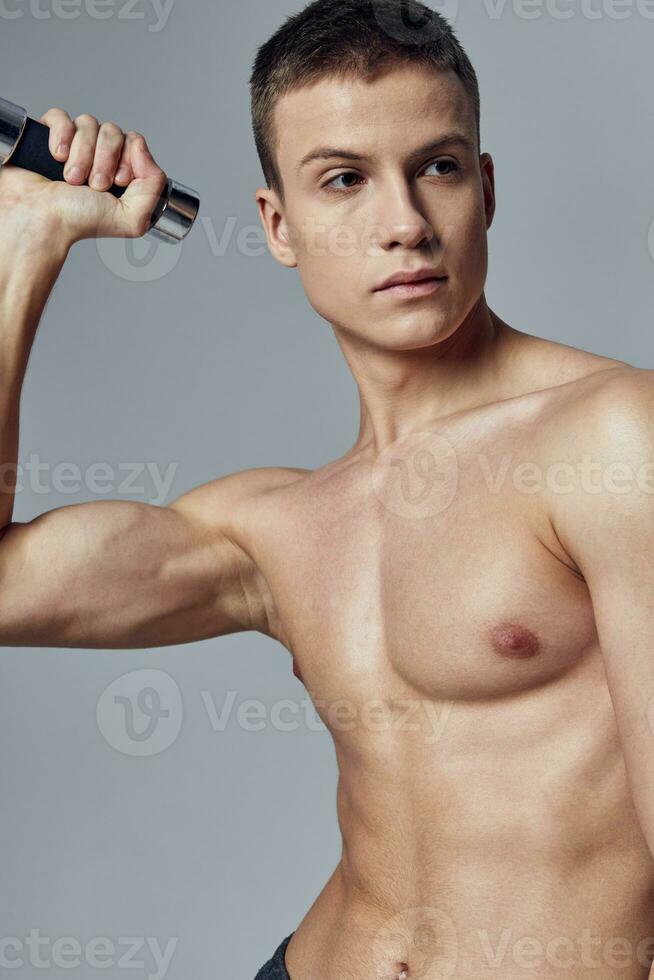 man holding dumbbells in his hands pumped up muscles posing photo