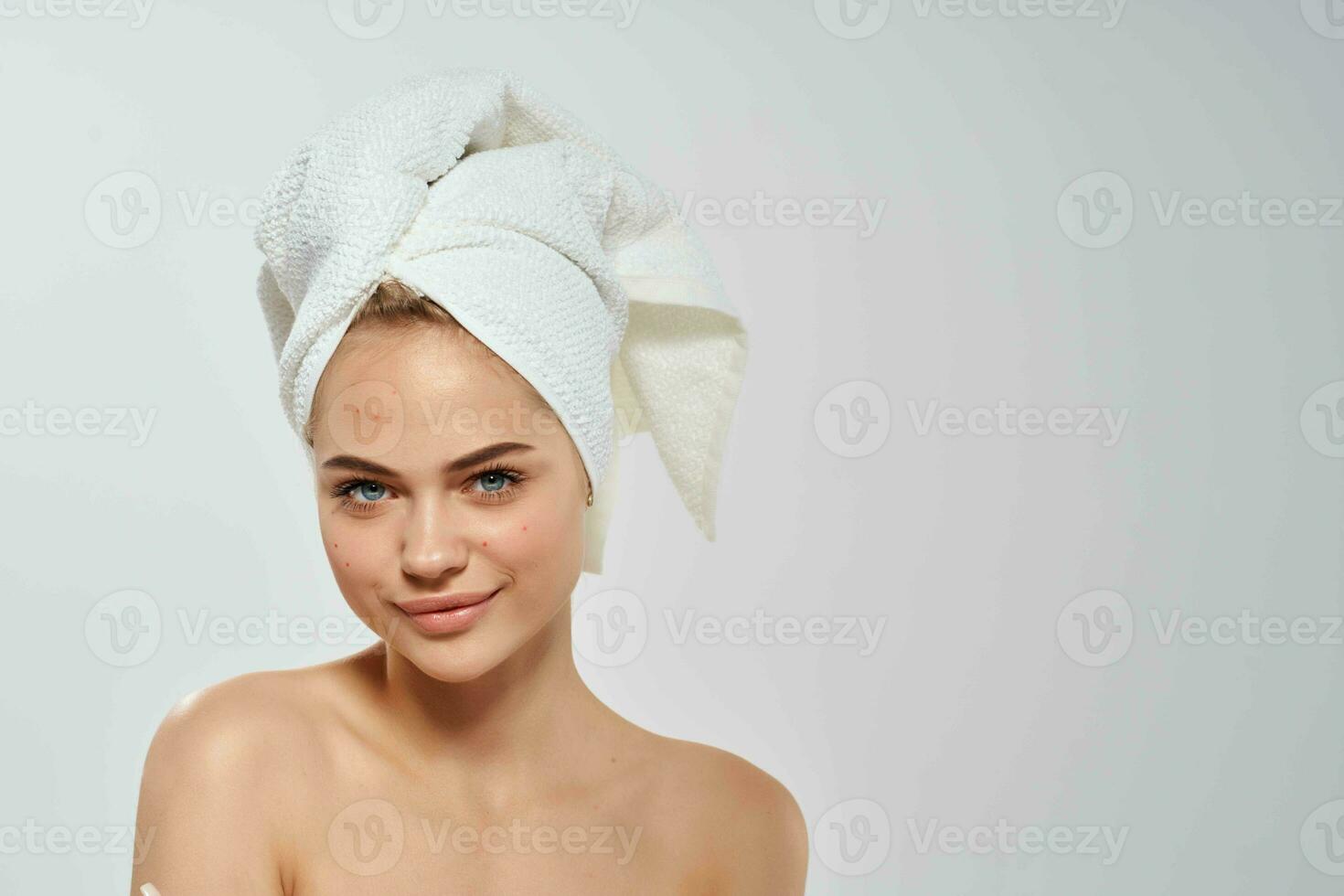 pretty woman with bare shoulders clear skin posing light background photo
