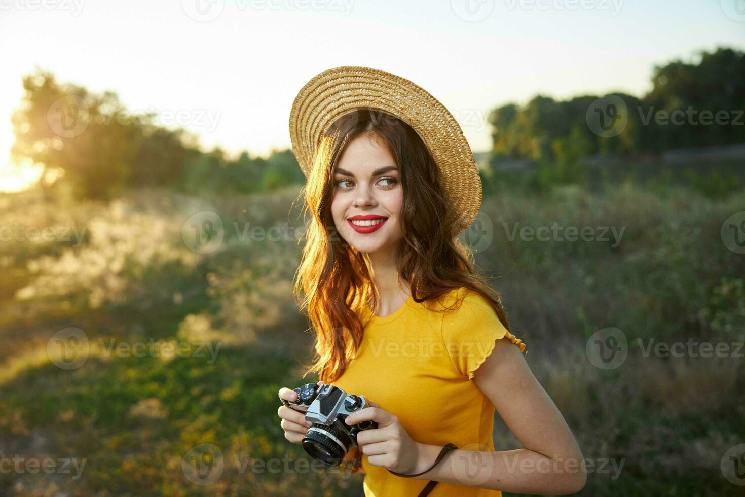 Pretty woman with camera on nature fresh air hat red lips hobby photo