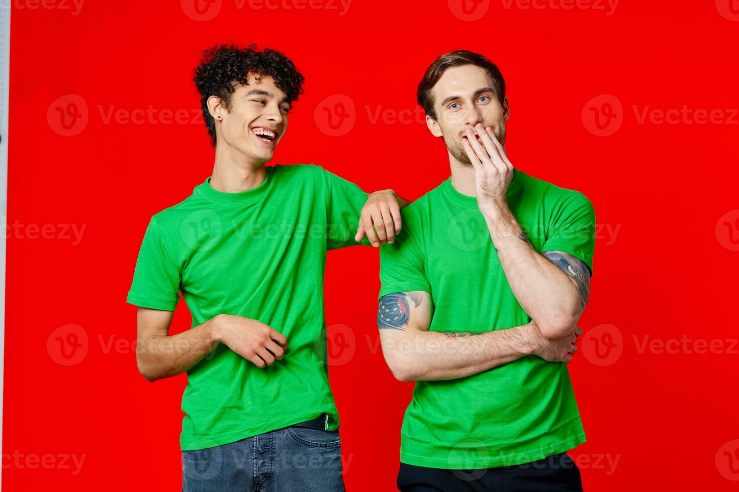 Two cheerful friends in green t-shirts are standing next to each other photo