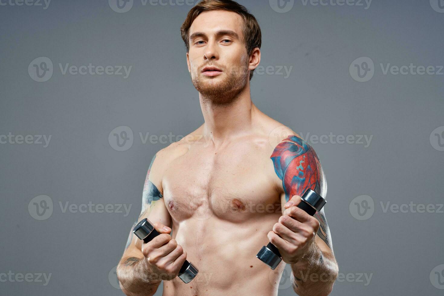 chico con un desnudo torso bombeado arriba brazo músculos pesas aptitud culturismo Deportes foto