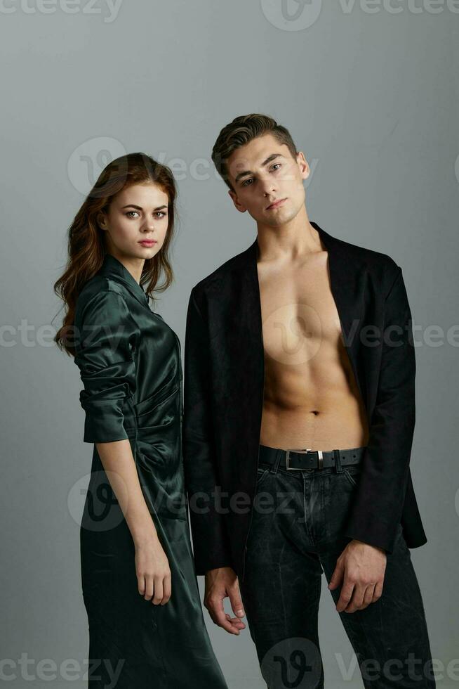 guy in unbuttoned jacket and woman in dress on gray background cropped view photo