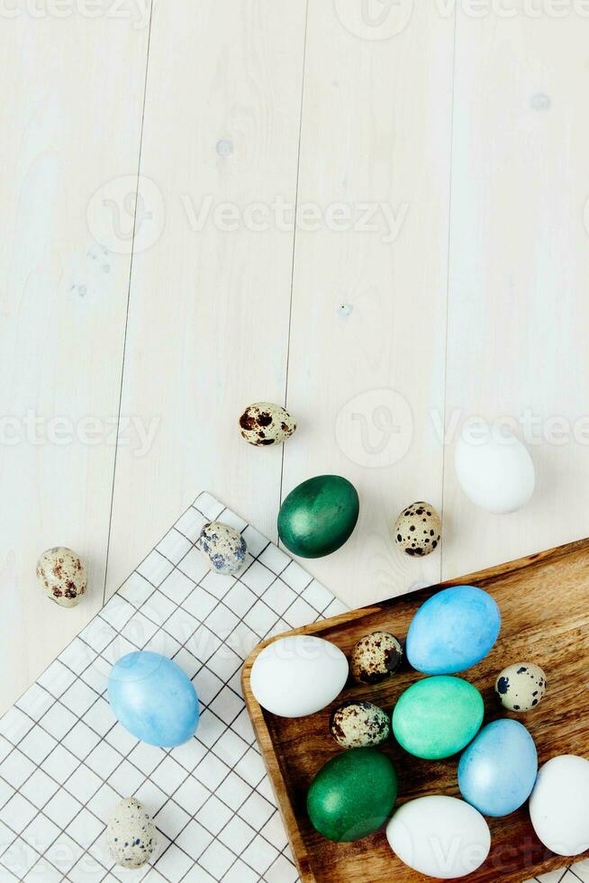 colorful eggs on checkered napkin and wooden background top view Easter tradition photo
