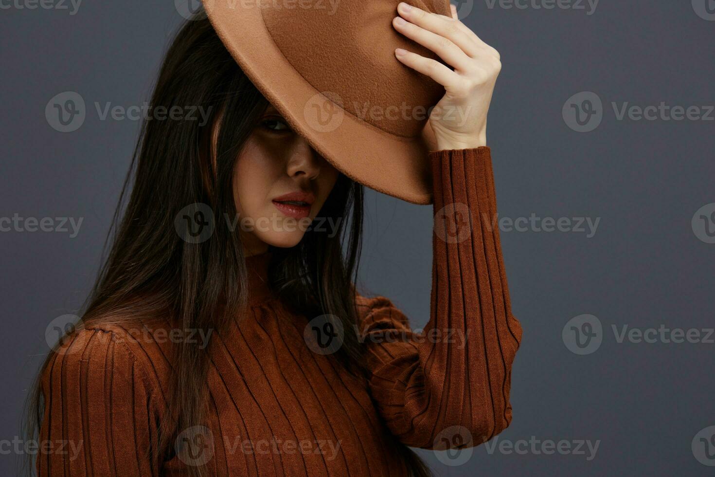 Brunette in Hat fun brown sweater posing casual wear Gray background photo