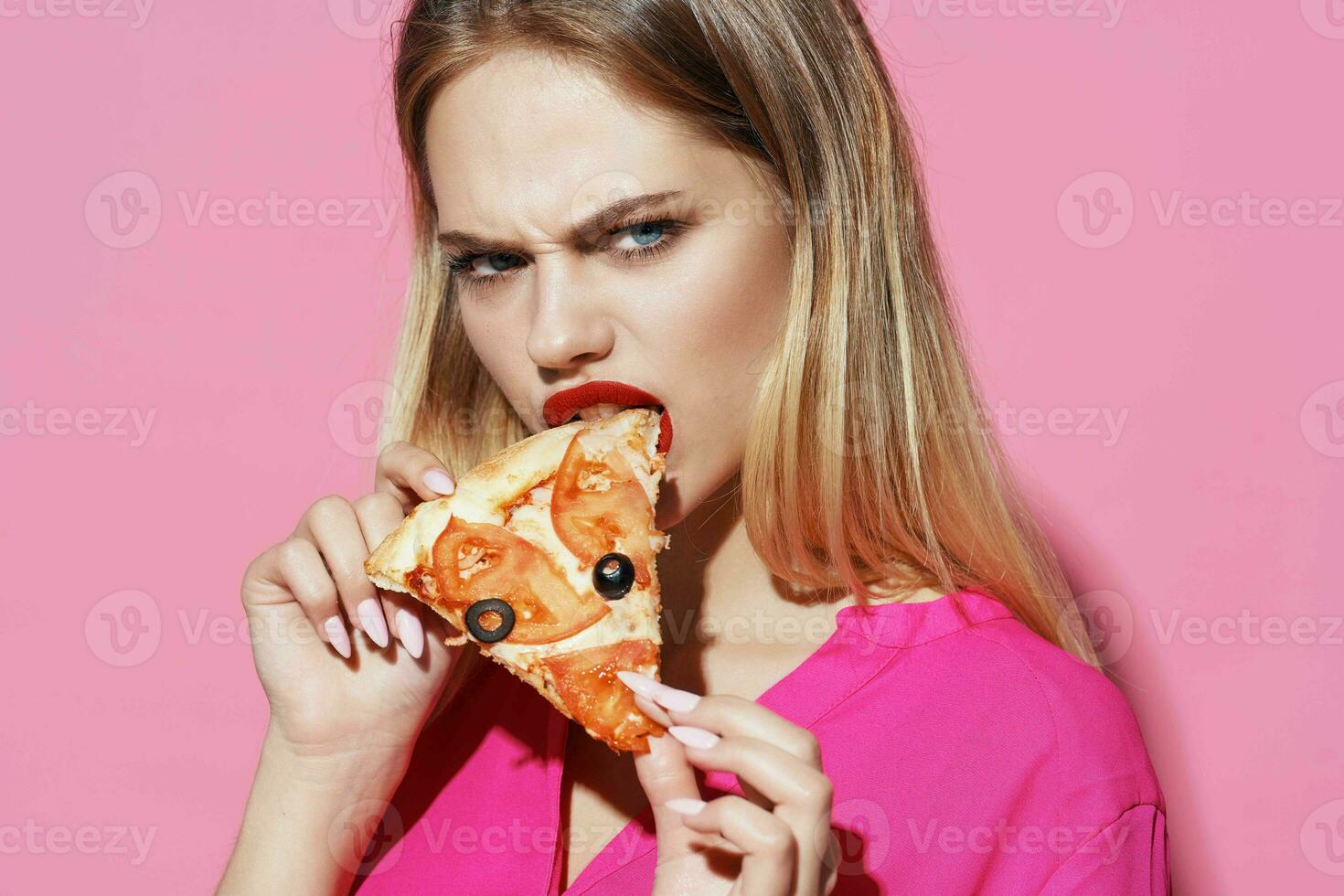 blonde eating pizza fast food pink background photo