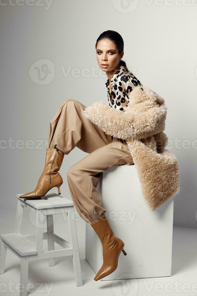 brunette in autumn clothes brown boots on the chair photo