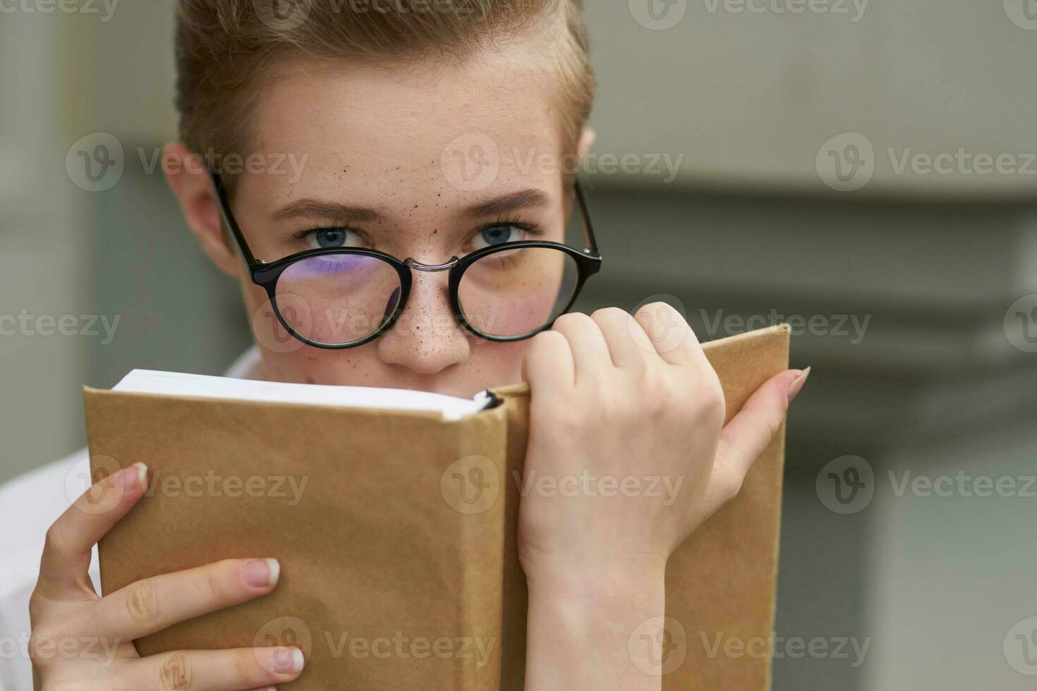 pretty woman with glasses walking around the city with a book communication photo