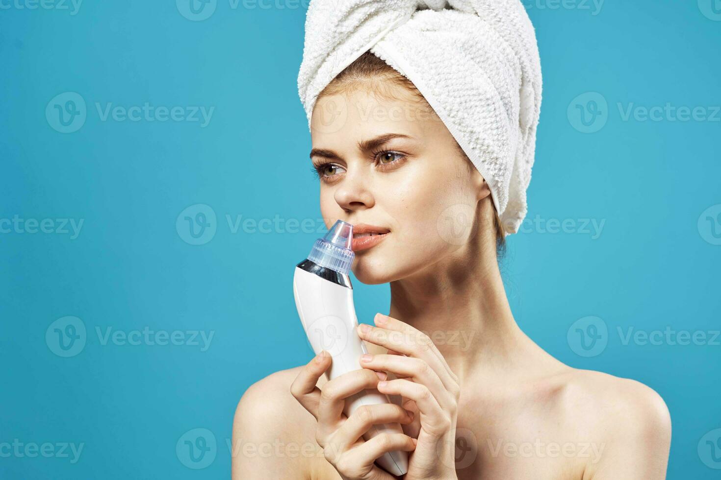 woman with towel on head cleaning face skin care blue background photo