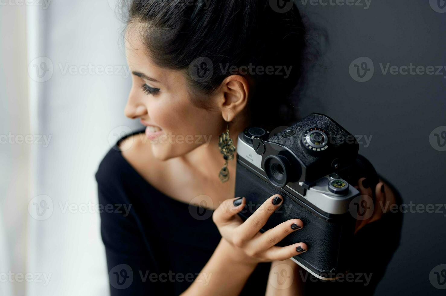 brunette in a black dress near the window posing lifestyle studio photo