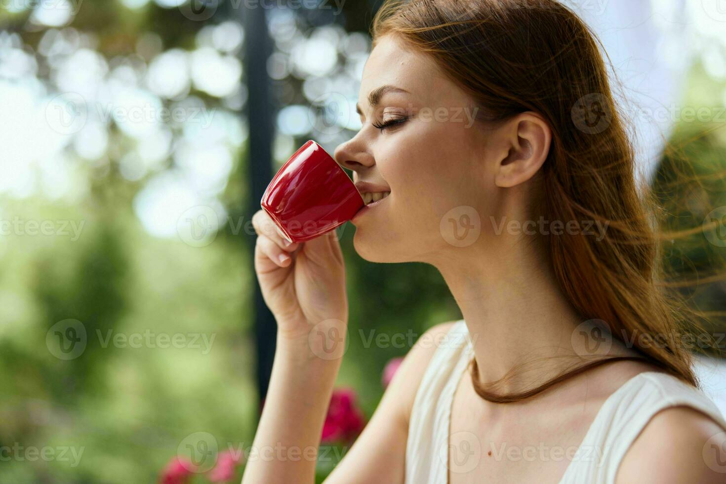 cheerful woman drinking coffee outdoors Happy female relaxing photo