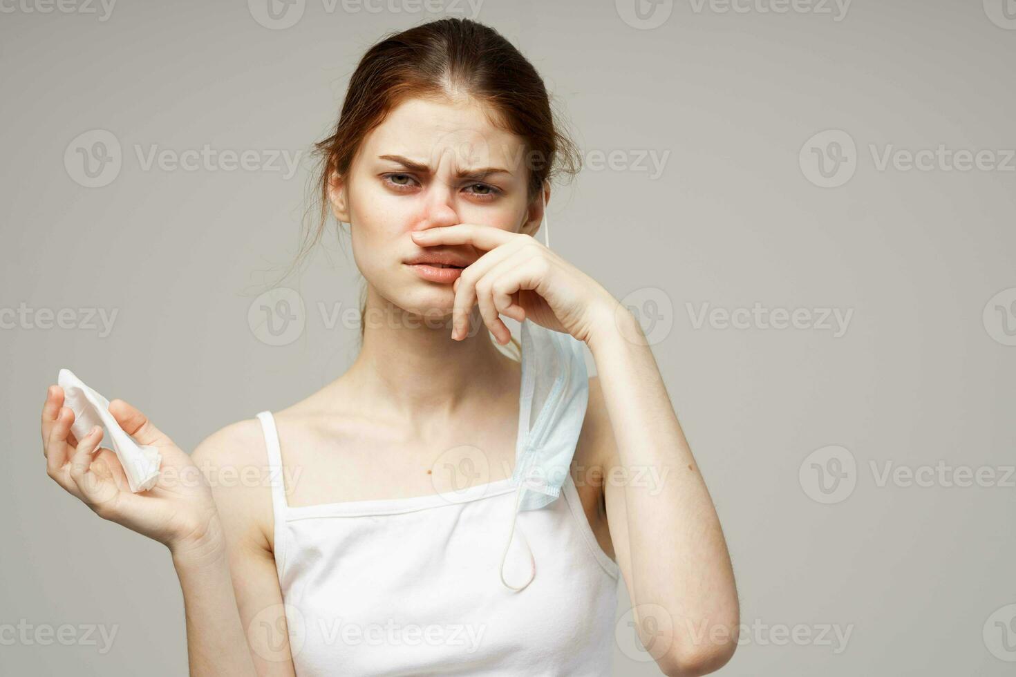 sick woman in white t-shirt with a scarf light background photo