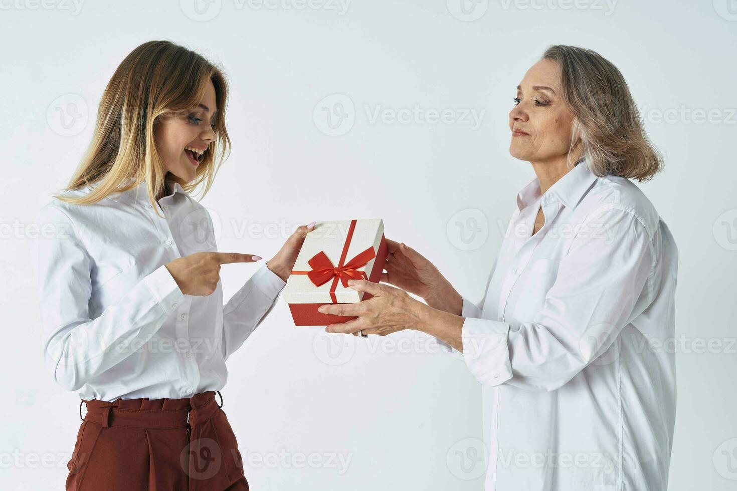 cute grandmother and granddaughter studio posing fun light background photo